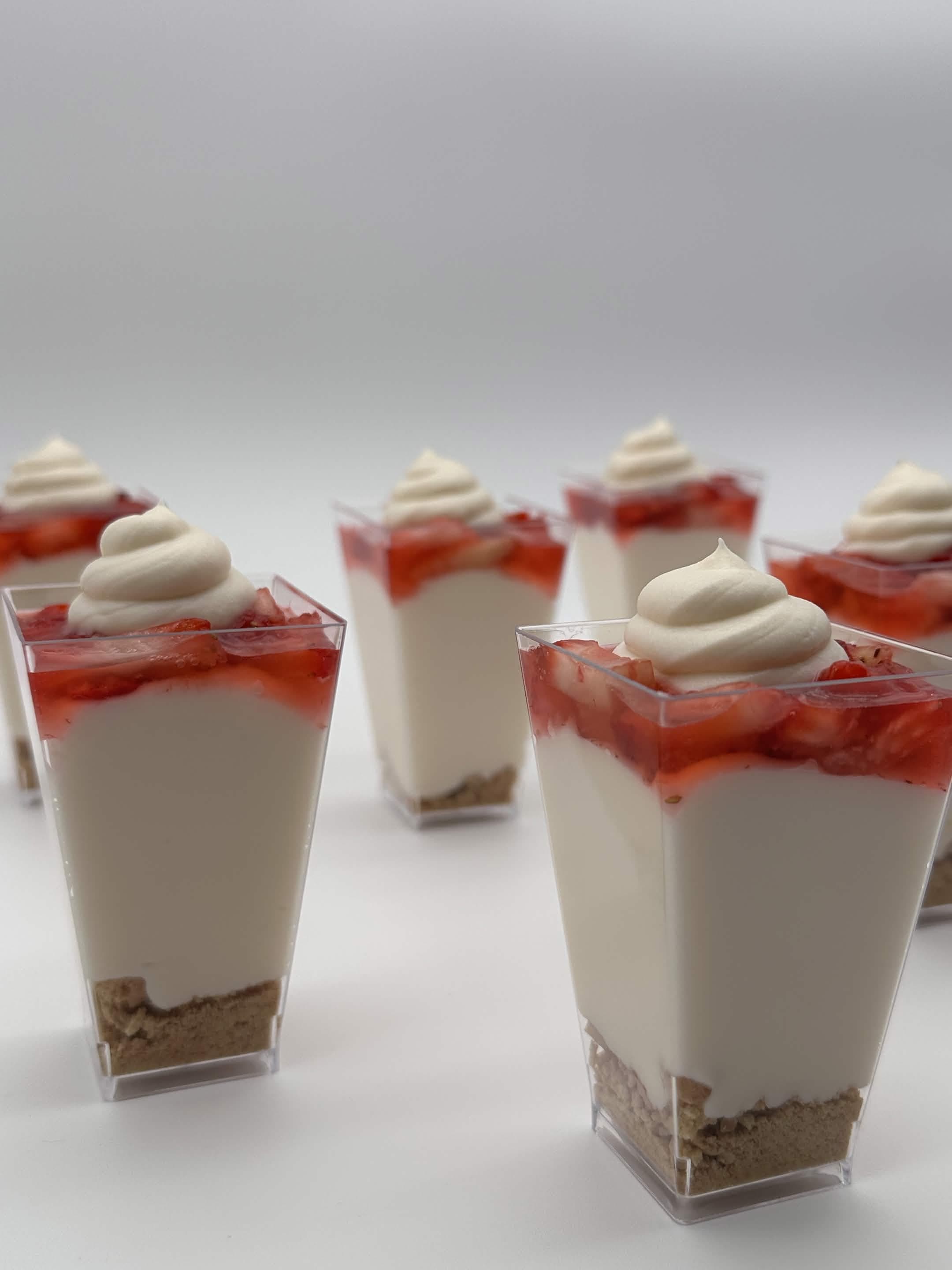 Layered dessert cups with cream and fruit.